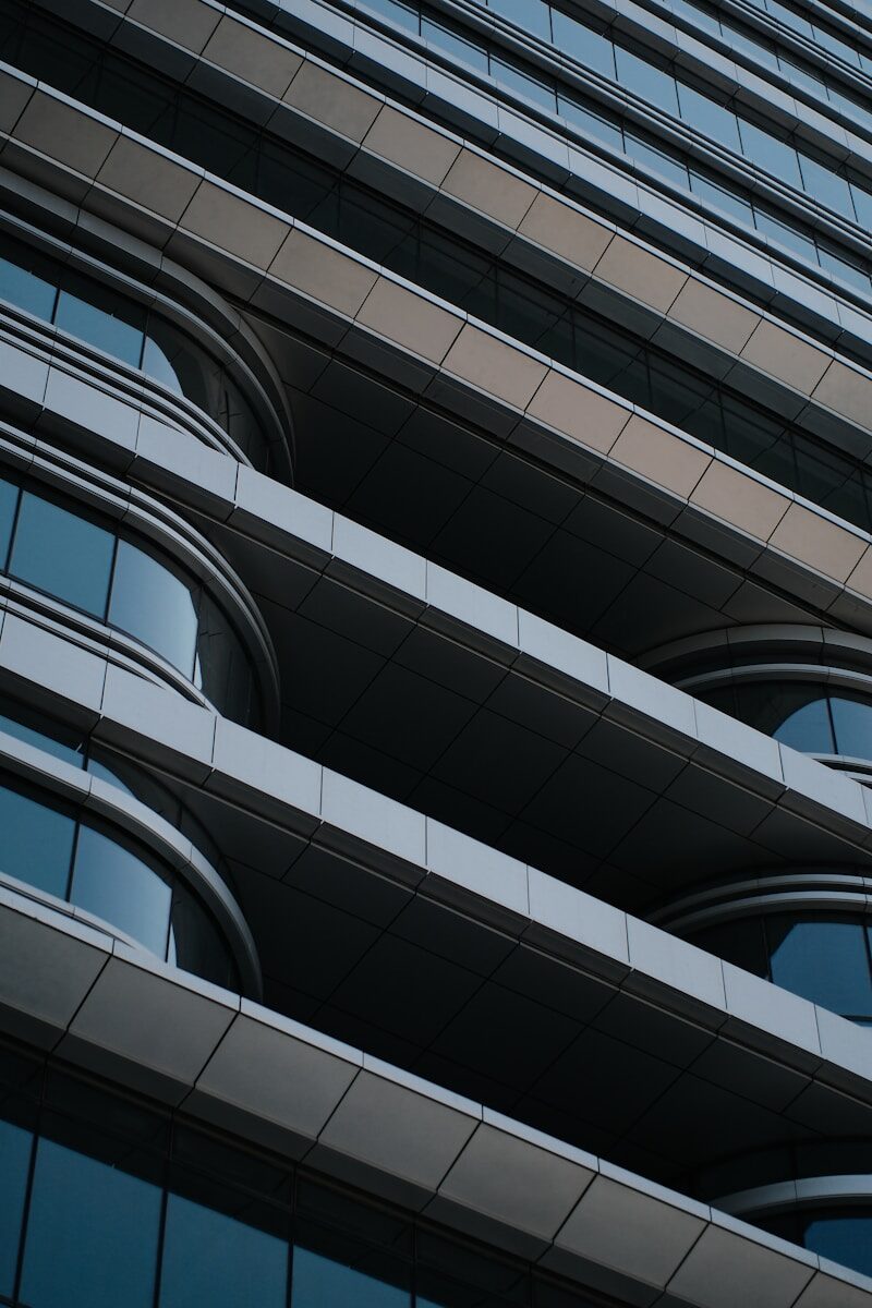 Modern building facade with curved windows and horizontal lines.